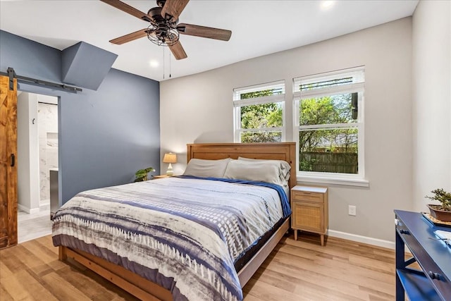 bedroom featuring baseboards, recessed lighting, a ceiling fan, a barn door, and light wood-style floors
