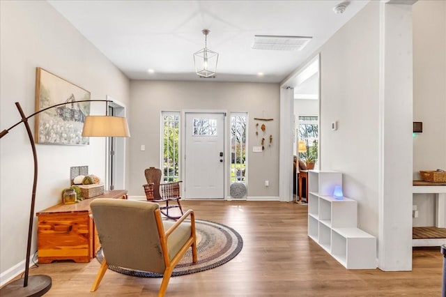 entryway featuring a healthy amount of sunlight, wood finished floors, baseboards, and visible vents
