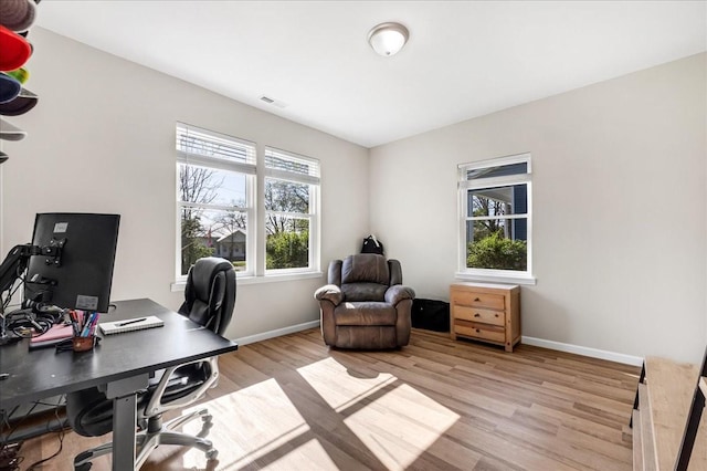 office area featuring visible vents, baseboards, and light wood finished floors
