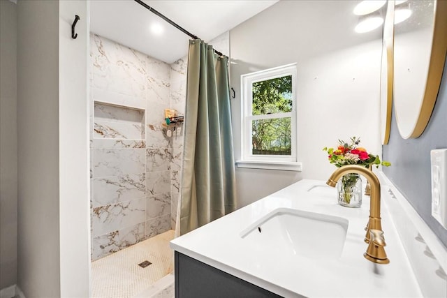 full bathroom featuring tiled shower and vanity