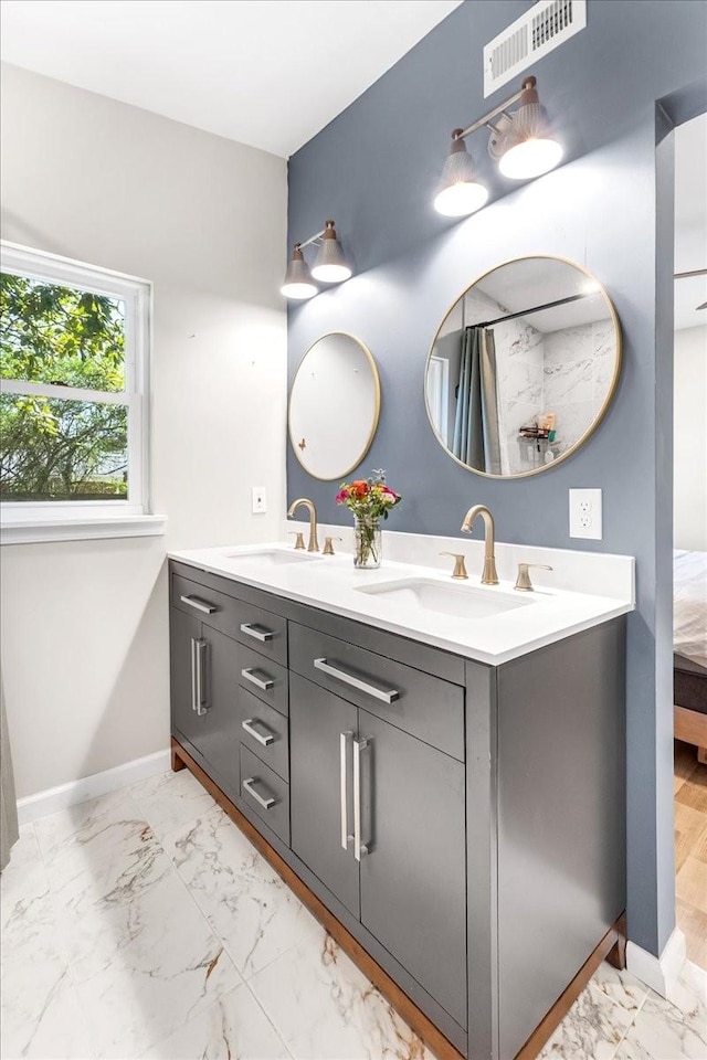 full bath featuring baseboards, marble finish floor, a sink, and visible vents