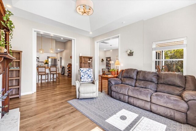 living room featuring recessed lighting, light wood-type flooring, and baseboards