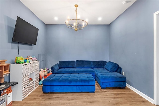 living area featuring a chandelier, light wood finished floors, baseboards, and recessed lighting