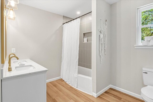 bathroom with baseboards, a sink, toilet, and wood finished floors