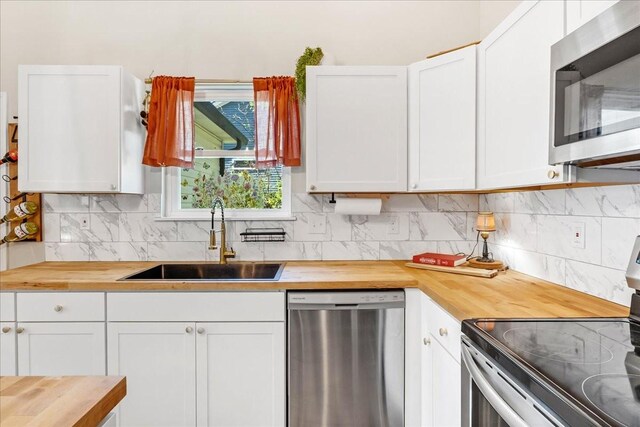 kitchen with a sink, butcher block countertops, and stainless steel appliances