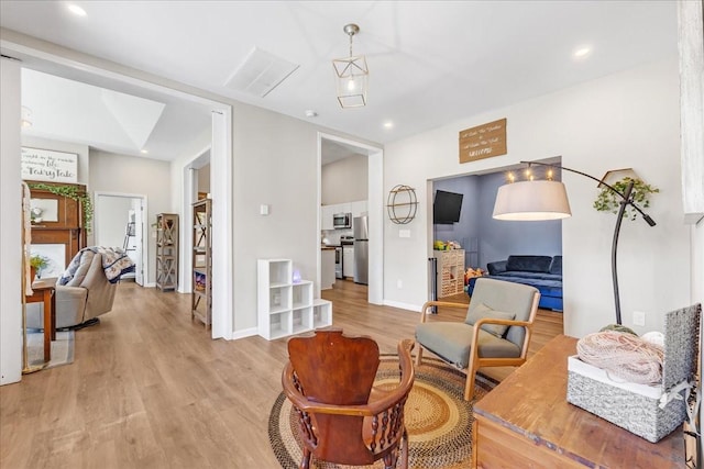 living area with baseboards, recessed lighting, and light wood-style floors