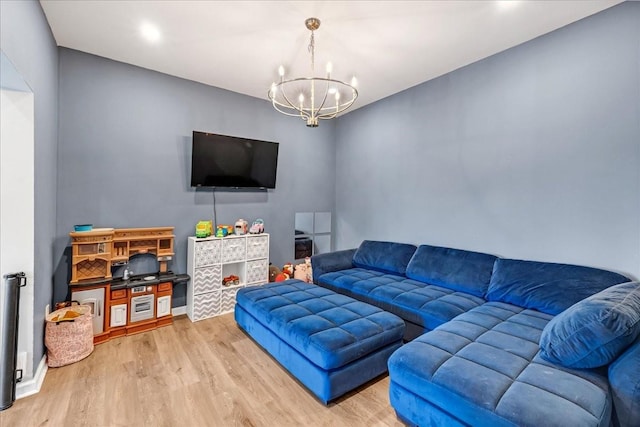 living area featuring a notable chandelier, baseboards, and wood finished floors