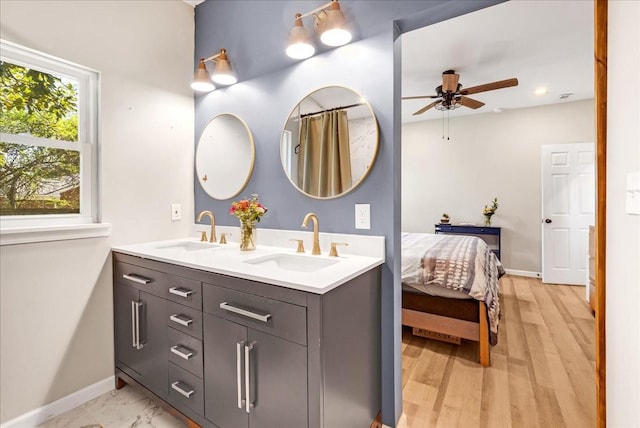 full bathroom featuring double vanity, baseboards, a sink, and a ceiling fan