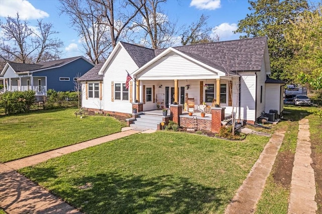 bungalow featuring a front lawn, covered porch, and roof with shingles