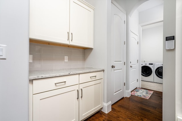 laundry room with dark wood finished floors, washing machine and clothes dryer, and laundry area