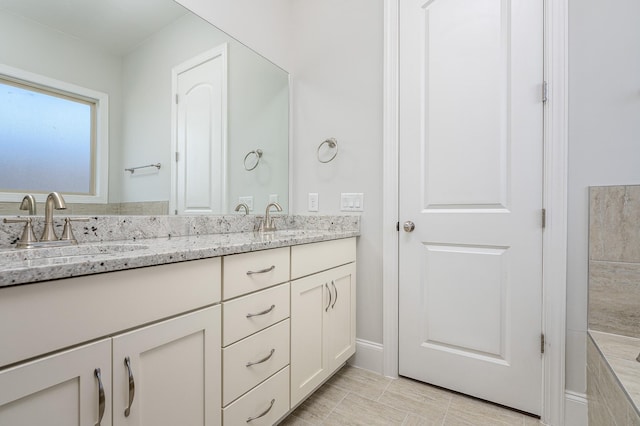 full bathroom with double vanity and a sink