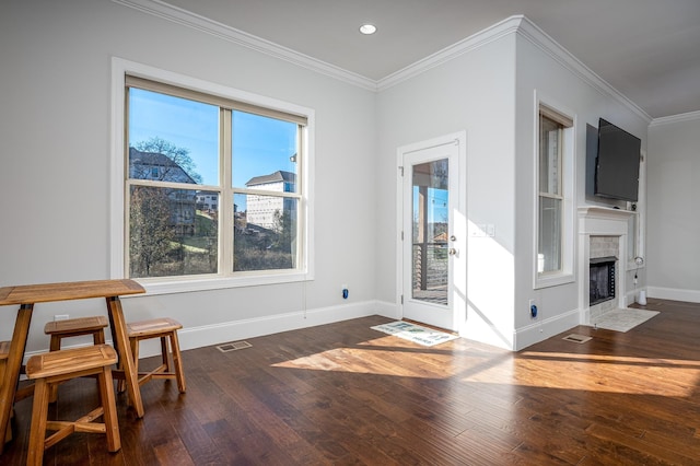 interior space with baseboards, visible vents, crown molding, and wood-type flooring