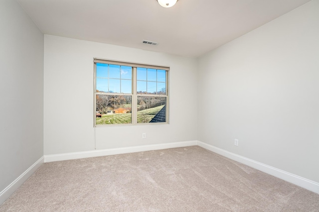 carpeted spare room with baseboards and visible vents