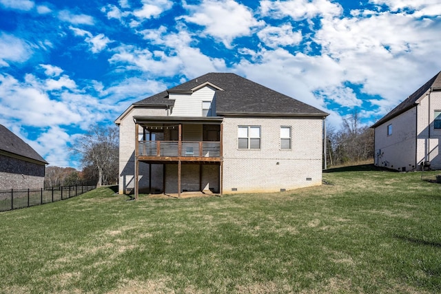rear view of property featuring fence, brick siding, a lawn, a shingled roof, and crawl space