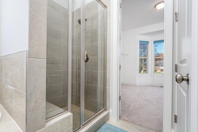 full bathroom with a stall shower and baseboards
