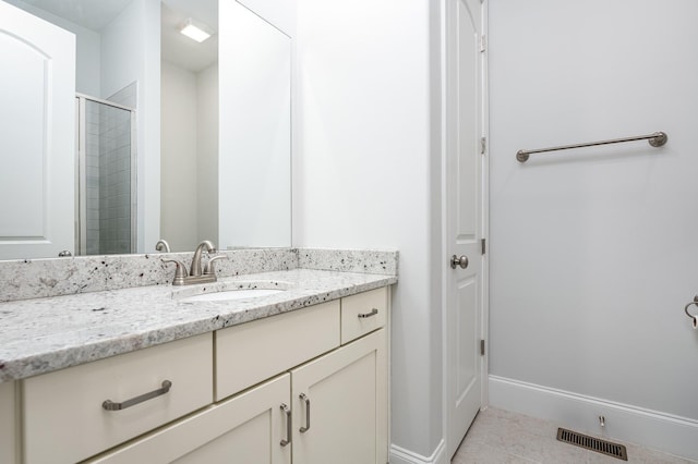 bathroom featuring tile patterned floors, tiled shower, vanity, baseboards, and visible vents