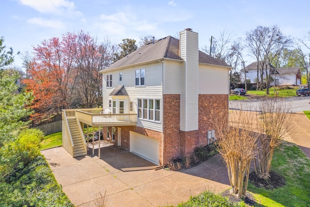 812 Deer Foot Ct, Nashville, TN 37221 - rear view of property featuring concrete driveway, stairs, brick siding, a garage, and a chimney
