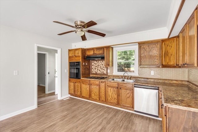 1309 Ovoca Rd, Tullahoma, TN 37388 - kitchen featuring black appliances, a sink, brown cabinetry, under cabinet range hood, and tasteful backsplash