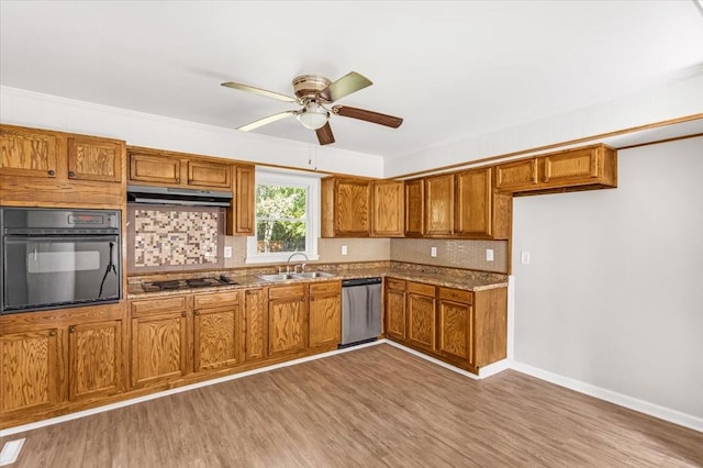 1309 Ovoca Rd, Tullahoma, TN 37388 - kitchen with black oven, stainless steel dishwasher, brown cabinets, under cabinet range hood, and backsplash