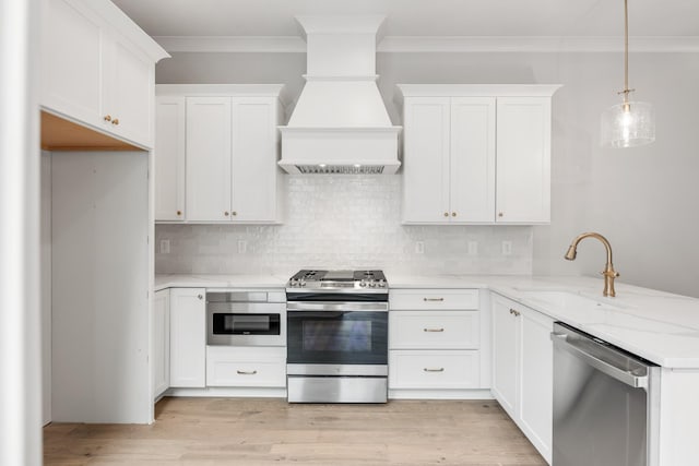 3180 Long Branch Cir, Franklin, TN 37064 - kitchen with light wood-type flooring, custom range hood, stainless steel appliances, decorative backsplash, and a sink