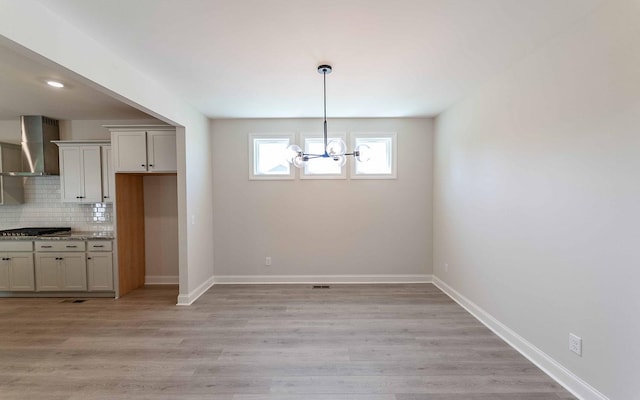 156 John T Alexander Blvd, Hendersonville, TN 37075 - unfurnished dining area with a chandelier, baseboards, and light wood-style flooring