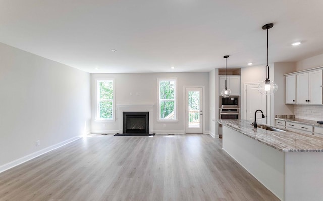 156 John T Alexander Blvd, Hendersonville, TN 37075 - unfurnished living room featuring a sink, light wood-style flooring, recessed lighting, a glass covered fireplace, and baseboards