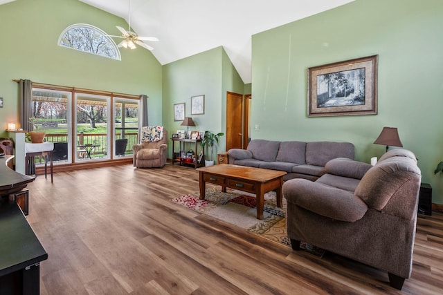 living room with wood finished floors, high vaulted ceiling, and ceiling fan