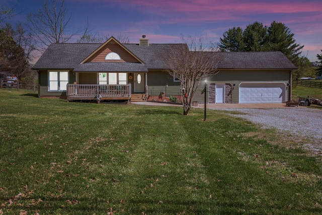 view of front of house with an attached garage, a chimney, a front yard, roof with shingles, and driveway