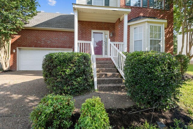 4009 Wellington Ct, Old Hickory, TN 37138 - doorway to property featuring brick siding, asphalt driveway, a shingled roof, and an attached garage