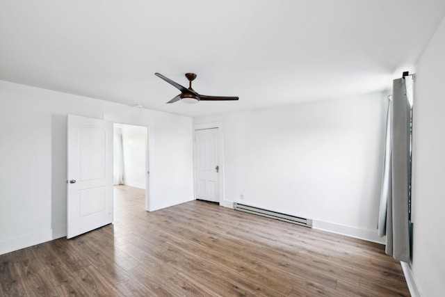 unfurnished room featuring a baseboard radiator, a ceiling fan, wood finished floors, and baseboards