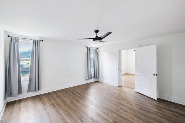 unfurnished room with wood finished floors, baseboards, and a ceiling fan