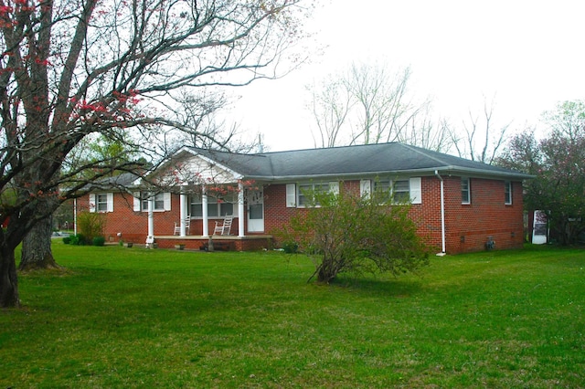 ranch-style house with a front yard and brick siding