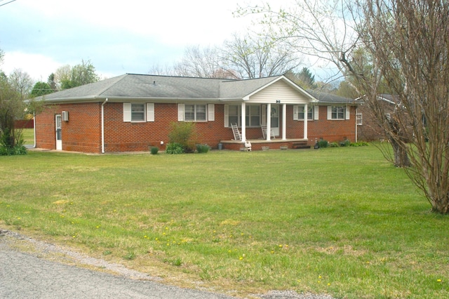 ranch-style home featuring covered porch, a front lawn, and brick siding