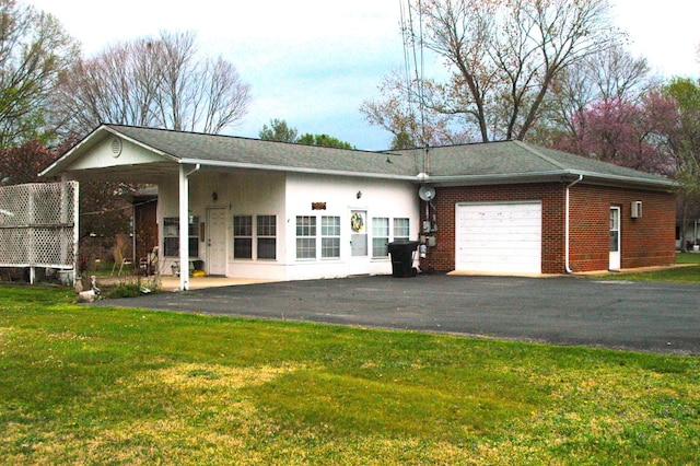 exterior space featuring a front yard, a garage, and aphalt driveway