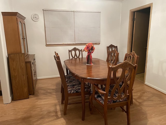 dining space featuring light wood finished floors and baseboards