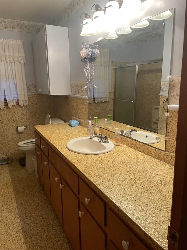 full bathroom with visible vents, toilet, tile walls, vanity, and a stall shower