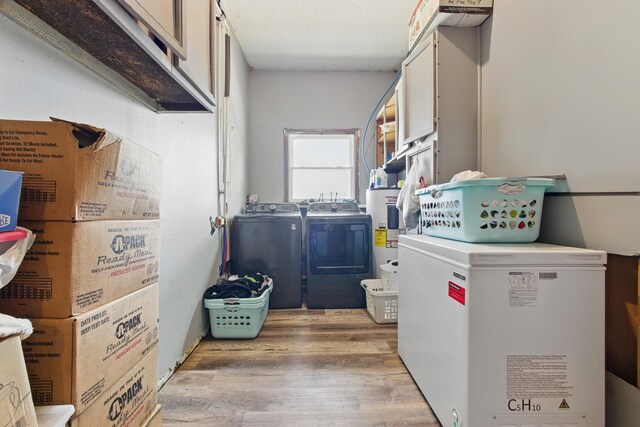 12 Dukes Ln, Kelso, TN 37348 - laundry area with electric water heater, light wood finished floors, washing machine and dryer, and cabinet space