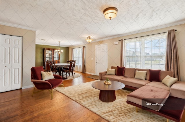 living room featuring baseboards, plenty of natural light, ornamental molding, and wood finished floors