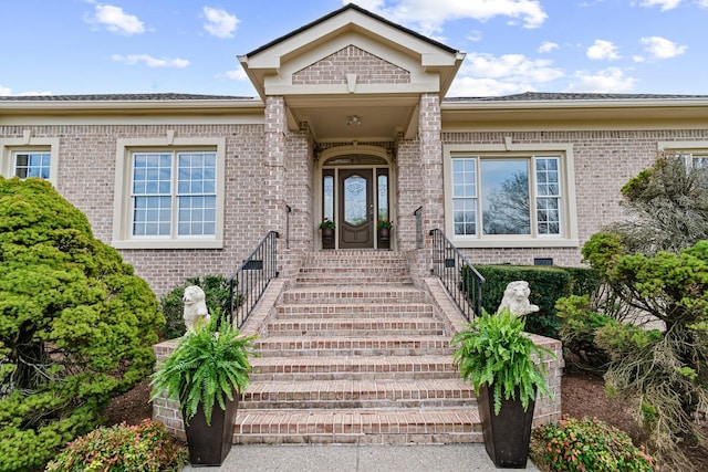 view of exterior entry featuring brick siding
