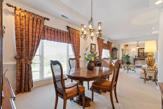 dining room with crown molding, visible vents, light colored carpet, and a chandelier
