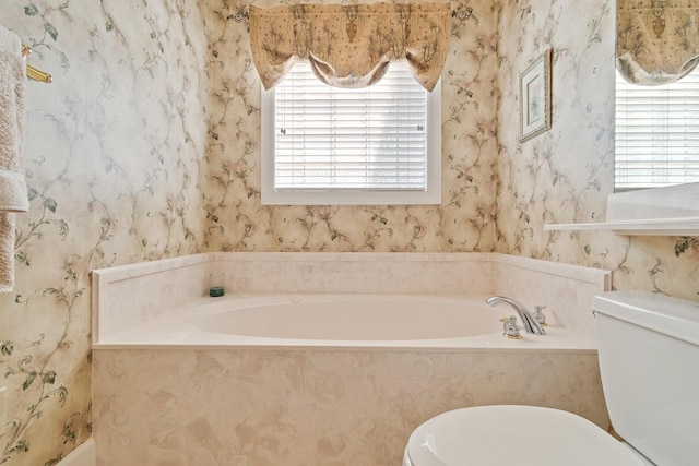 bathroom featuring a bath, toilet, and wallpapered walls