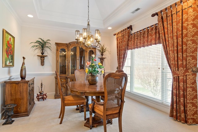 dining area featuring a tray ceiling, light colored carpet, an inviting chandelier, and crown molding