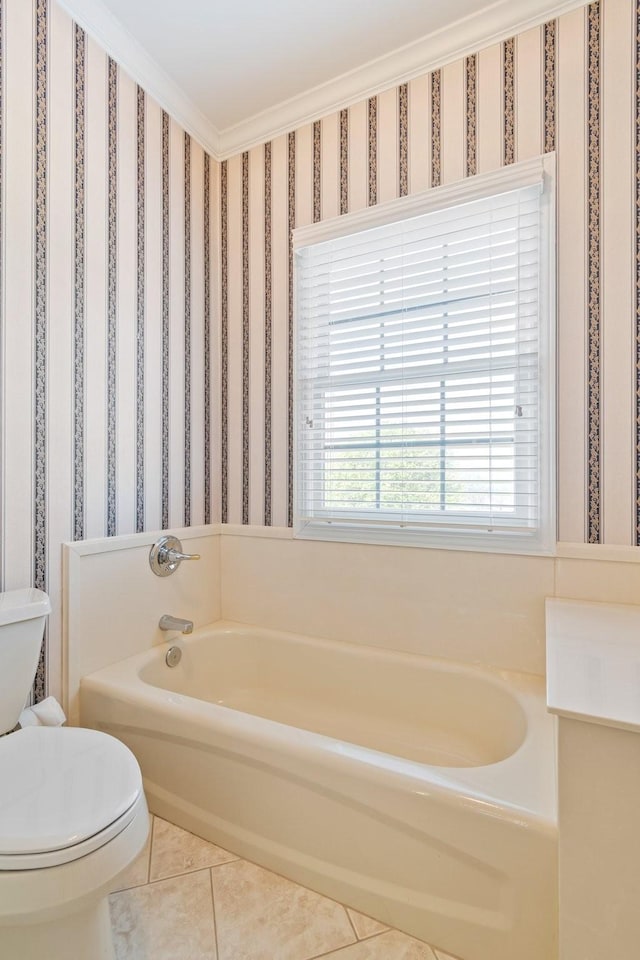 bathroom featuring tile patterned flooring, a garden tub, wallpapered walls, and toilet