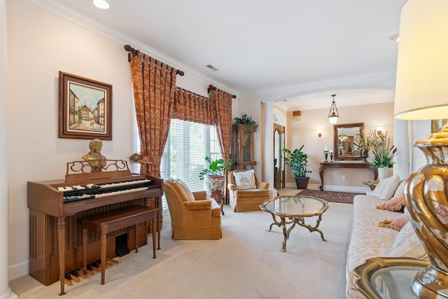 living area with decorative columns, carpet flooring, baseboards, and ornamental molding