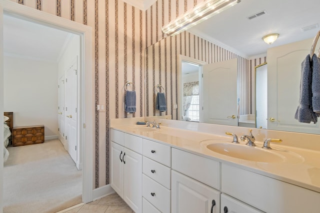 bathroom featuring a sink, visible vents, crown molding, and wallpapered walls