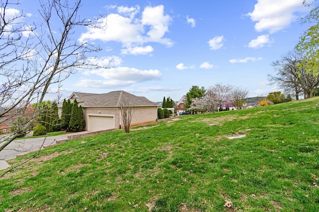view of yard featuring concrete driveway and an attached garage