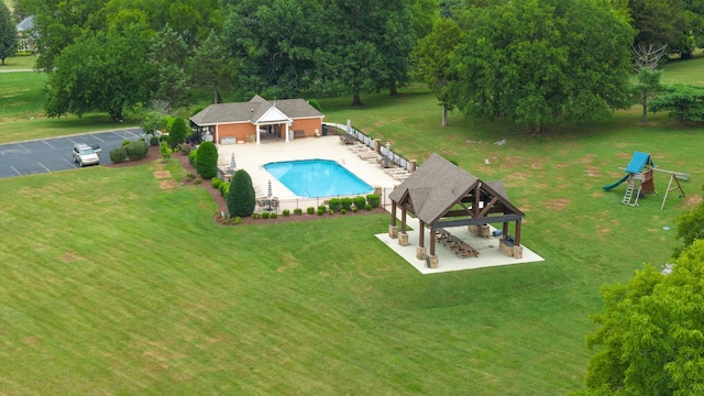 view of pool with a lawn, a patio, outdoor dry bar, a gazebo, and a fenced in pool
