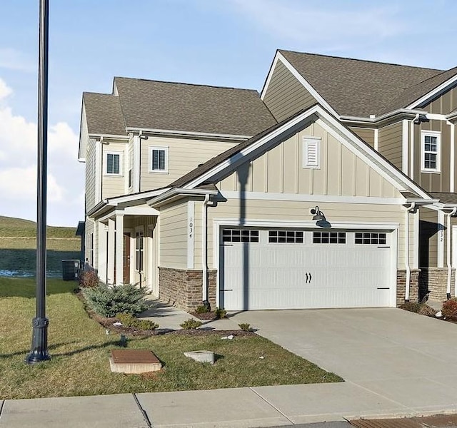 view of front facade featuring stone siding, a garage, board and batten siding, concrete driveway, and central air condition unit