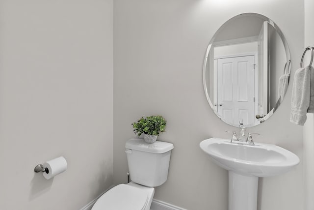 bathroom with baseboards and toilet