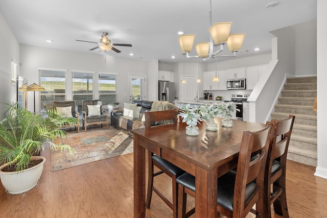 dining room with light wood-style flooring, recessed lighting, a ceiling fan, and stairway
